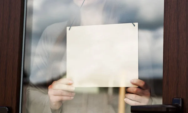 Woman Holds Blank Wooden Sign Glass Door — Stock Photo, Image