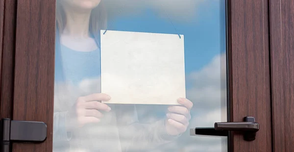 Frau Hält Leeres Holzschild Hinter Glastür — Stockfoto