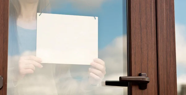 Frau Hält Leeres Holzschild Hinter Glastür — Stockfoto