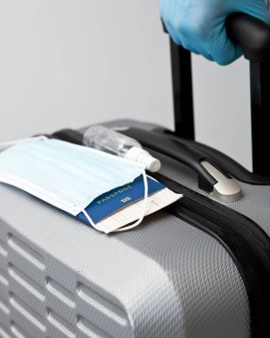 Adamın elinde pasaport ve elinde tıbbi maske var. Plastik eldiven takıyor. Olay sonrası zaman yolculuğunda çok önemli bir şey.