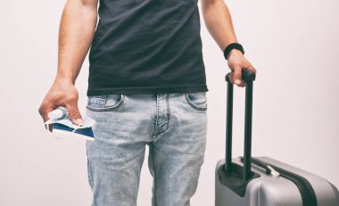 Pasaportu elinde tutan adam, elinde tren bileti ve tıbbi maskeyle, 19 'uncu yüzyıl sonrası seyahatinde olmazsa olmaz bir şey.