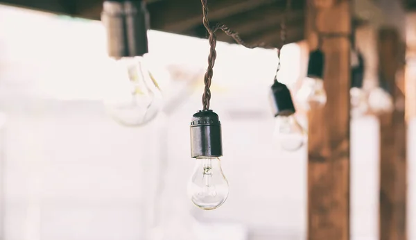 The garland of  light bulbs hanging on the wooden terrace