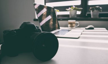 Fotoğrafçılığın işyeri. Fotoğraf ekipmanı ve dizüstü bilgisayarın üst görüntüsü