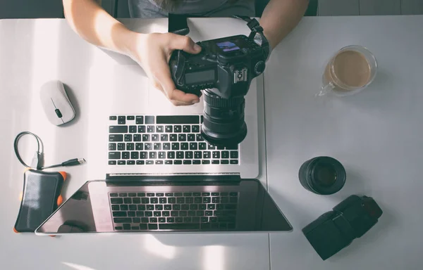 Fotógrafo Está Trabalhando Laptop Muitos Equipamentos Fotográficos Deitados Mesa — Fotografia de Stock