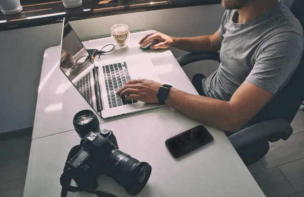 Fotógrafo Está Trabalhando Laptop Muitos Equipamentos Fotográficos Deitados Mesa — Fotografia de Stock