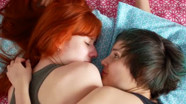 Lesbisk par gosa i sängen hemma i sovrummet — Stockvideo