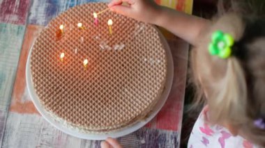 Küçük kız Işık mumlar bir ev yapımı kek üzerine. Özerklik kavramını.