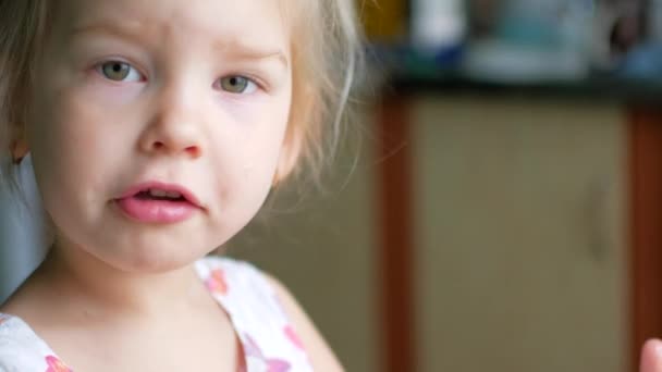 Una inyección de un niño lamiendo comida de su dedo. Luego se gira y sonríe . — Vídeos de Stock