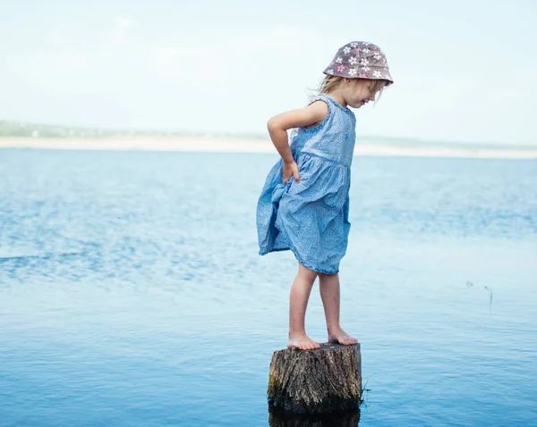 少女は湖で断端に立っています — ストック写真