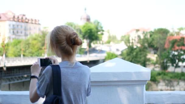 Μια νεαρή γυναίκα παίρνει μια φωτογραφία της πόλης ενώ ταξιδεύετε. — Αρχείο Βίντεο