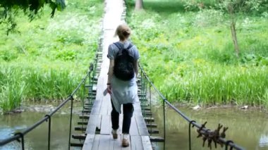 bir dağ nehir arasında bir köprü üzerinde duran kız gezgin