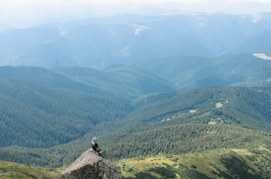 bir dağın tepesinde başarı kutluyor uzun yürüyüşe çıkan kimse