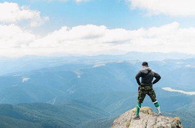 bir dağın tepesinde başarı kutluyor uzun yürüyüşe çıkan kimse