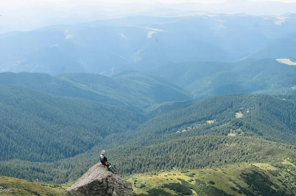 bir dağın tepesinde başarı kutluyor uzun yürüyüşe çıkan kimse
