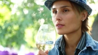 Hipster kadın eteklerinde şarap içme gülümseyen şapkalı
