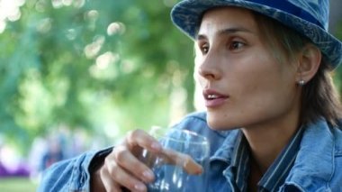 Hipster kadın eteklerinde şarap içme gülümseyen şapkalı