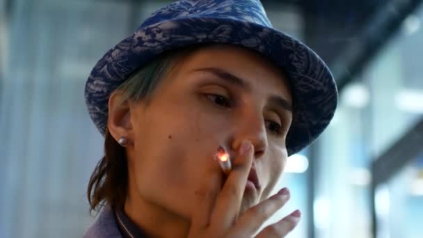 Девушка курит сигарету по ночам в городе. Снаружи, снаружи, в реальном времени, крупным планом, вид сбоку, на боковых фонарях — стоковое видео