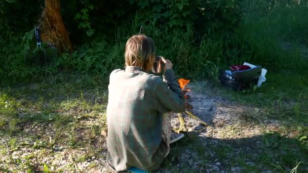 独立的年轻旅行女子徒步旅行者, 保持温暖和放松的篝火 — 图库视频影像