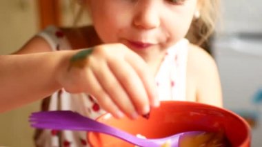 Bir çocuk plastik kavanoz 4 k üzerinden bir kaşık bal yiyor