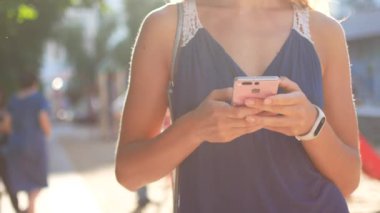 Güneşli şehir sokakları yürüyüş ve sohbet arkadaş, neşeli hippi kız açık havada cep telefonu kullanarak, gün batımı arka plan ile çekici genç kadın