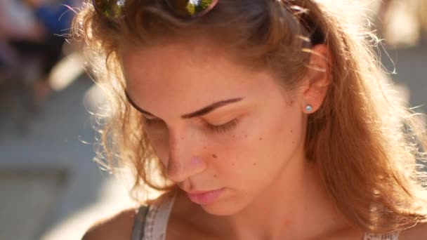 Jovem atraente andando nas ruas ensolaradas da cidade e conversando com amigos, menina hipster alegre usando o celular ao ar livre, fundo do pôr do sol — Vídeo de Stock