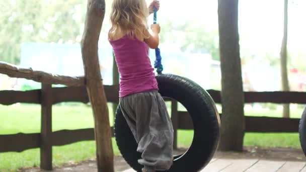 Little Blond Girl Riding Tire — Stock Video