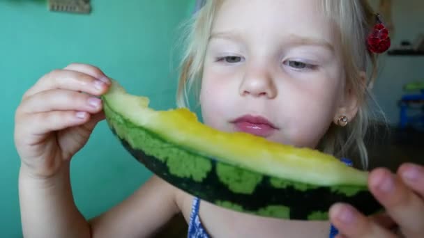 Niedliches kleines Mädchen isst gelbe Wassermelone — Stockvideo