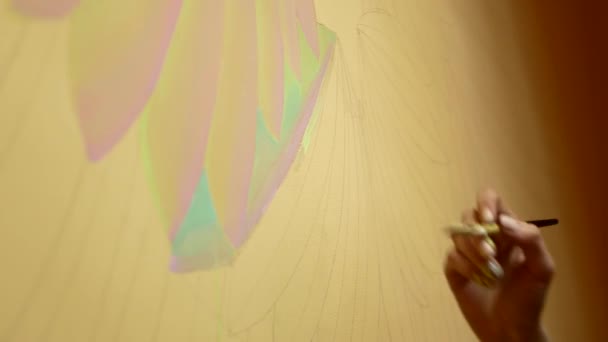 Jonge brunette schetst een beeld op de muur, profiel — Stockvideo
