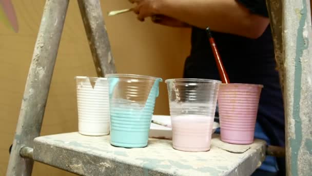 Multicolored paint in plastic cups. Artist paints — Stock Video