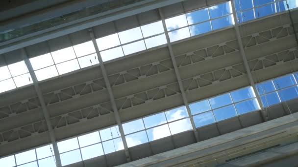 Снимок стеклянного потолка торгового центра на фоне замедленного света солнечных лучей на голубом небе — стоковое видео