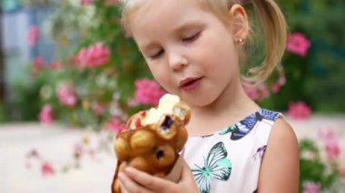 Harika bir küçük kız meyve ve dondurma ile Waffle yiyor. Yaz Cafe