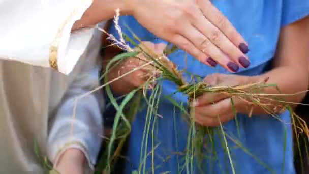 Mom learns a daughter to weave a wreath of hay — Stock Video