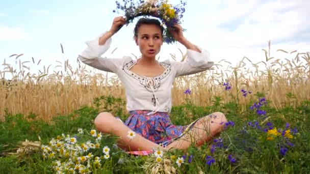 Mão menina sentar tece uma coroa de flores em sua cabeça. Lazer na fazenda rural — Vídeo de Stock