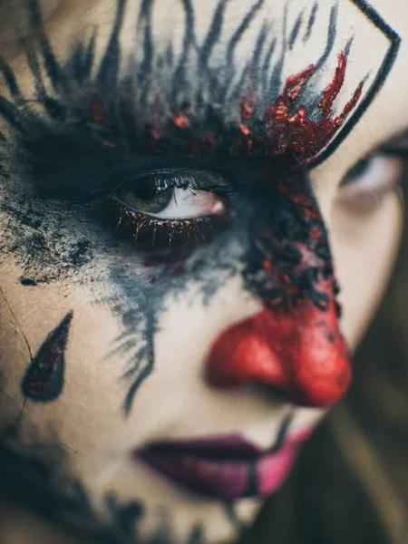 Halloween, het gezicht van een meisje is een pop, de verdieping van een gezicht is dood. Een vrouw met een afschuwelijk make-up. — Stockfoto