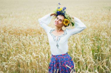 Ukraynalı kız güzel bir çelenk ile yaz çayır yürür. Kız nakış ile etnik elbise giymiş. Ivan Kupala bayram.