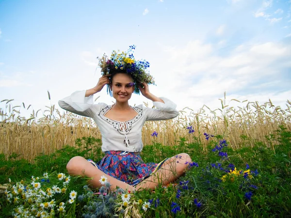 Una ragazza ucraina in abiti nazionali corona una corona nel campo — Foto Stock