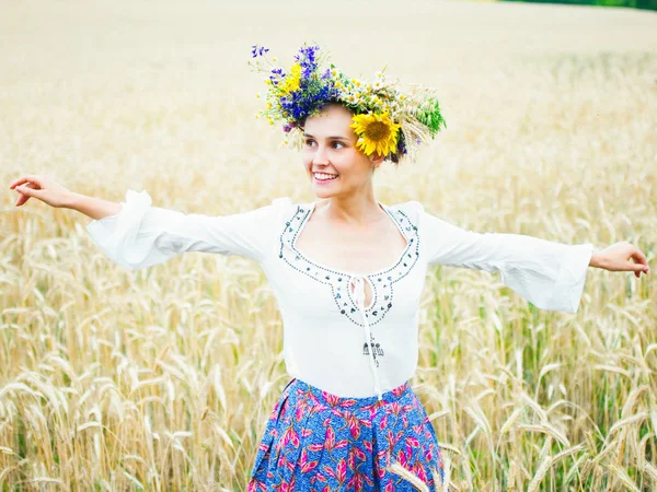 Ein ukrainisches Mädchen in einem schönen Kranz geht durch die Sommerwiese. Das Mädchen trägt ethnische Kleidung mit Stickereien. Fest des ivan kupala — Stockfoto