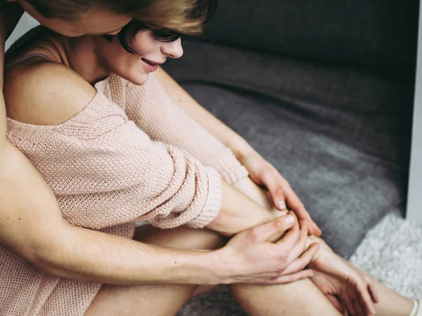 Ein Mann und eine Frau in intimer Nähe. ein Mann umarmt die Beine einer Frau. — Stockfoto