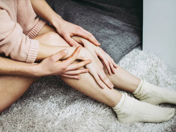 Een man en een vrouw in intieme nabijheid. Een man hugs de benen van een vrouw. — Stockfoto