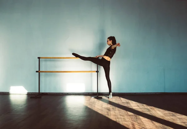 En ung flicka gör stretching i dance hall. — Stockfoto