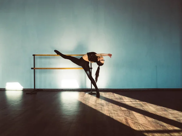 A young girl is doing stretching in the dance hall. — Stock Photo, Image