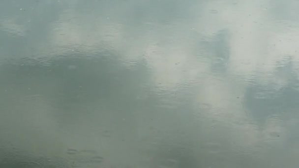 La pluie tombe sur la surface de la piscine. Fond naturel, jour d'automne nuageux .