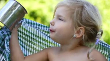 Çocuk ormanda çay içiyor