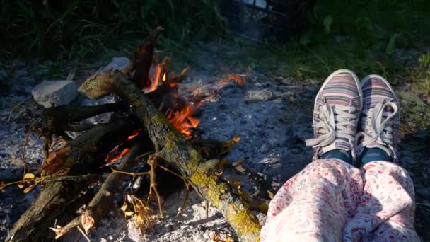 Žena nohy v botách ohřívali v blízkosti hořící oheň v chatě. Útulný krb — Stock video
