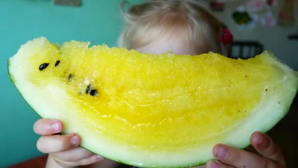 Schattig klein meisje geel watermeloen te eten — Stockvideo