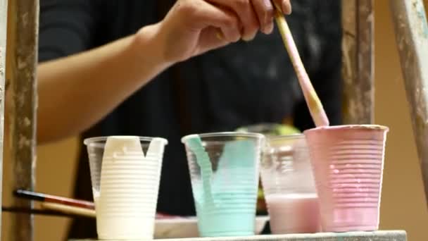 Vernice multicolore in bicchieri di plastica. Pitture d'artista — Video Stock