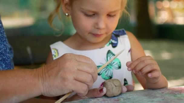 Una bambina scolpisce statuette di argilla con l'aiuto di sua nonna — Video Stock