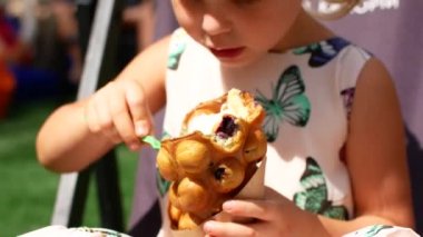 Harika bir küçük kız meyve ve dondurma ile Waffle yiyor. Yaz Cafe