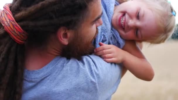 Padre divirtiéndose sosteniendo a su pequeña hija rubia en brazos — Vídeos de Stock