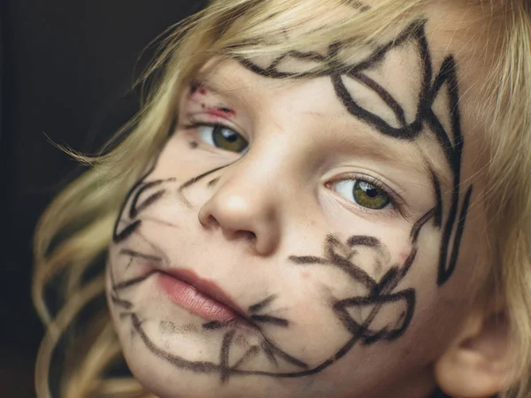 Het kleine meisje haar gezicht geschilderd met een marker. Make-up voor Halloween. — Stockfoto